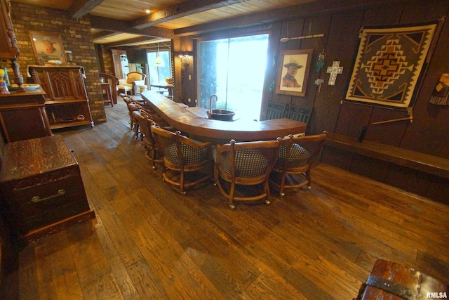 dining area with wood ceiling, beam ceiling, hardwood / wood-style flooring, and wooden walls