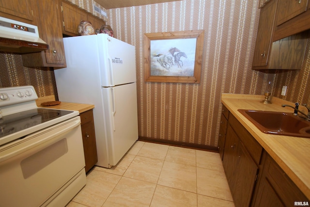 kitchen featuring light tile patterned floors, sink, and white appliances