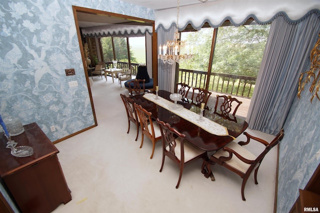 carpeted dining room featuring an inviting chandelier