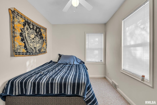 carpeted bedroom featuring ceiling fan and multiple windows