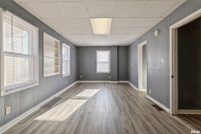 spare room featuring hardwood / wood-style floors and a paneled ceiling