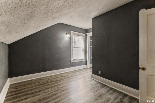 bonus room featuring hardwood / wood-style flooring, a textured ceiling, and lofted ceiling