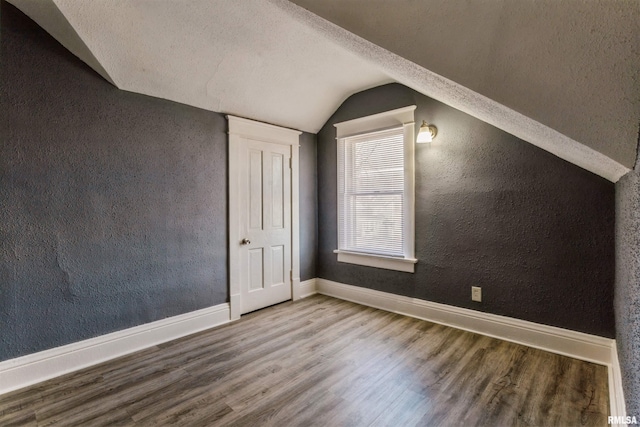 bonus room featuring hardwood / wood-style floors, a textured ceiling, and vaulted ceiling