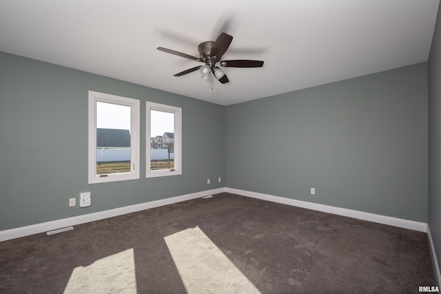 carpeted spare room featuring ceiling fan