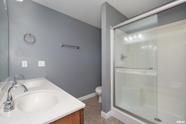 bathroom with tile patterned floors, toilet, an enclosed shower, a textured ceiling, and vanity