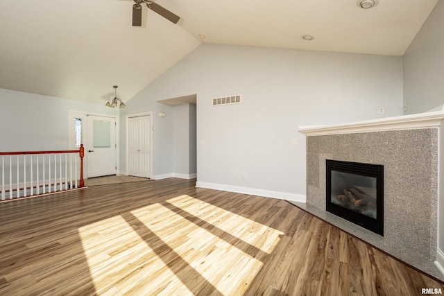 unfurnished living room with ceiling fan, high vaulted ceiling, a fireplace, and hardwood / wood-style floors