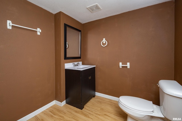 bathroom featuring vanity, hardwood / wood-style floors, and toilet