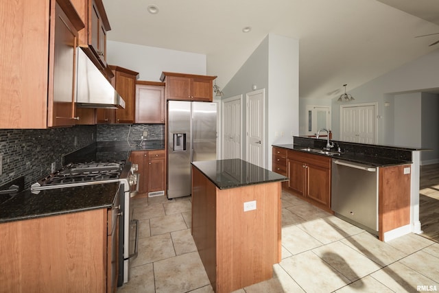 kitchen with sink, appliances with stainless steel finishes, a kitchen island, dark stone counters, and decorative backsplash