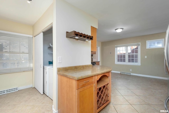 kitchen featuring washer and dryer and light tile patterned floors