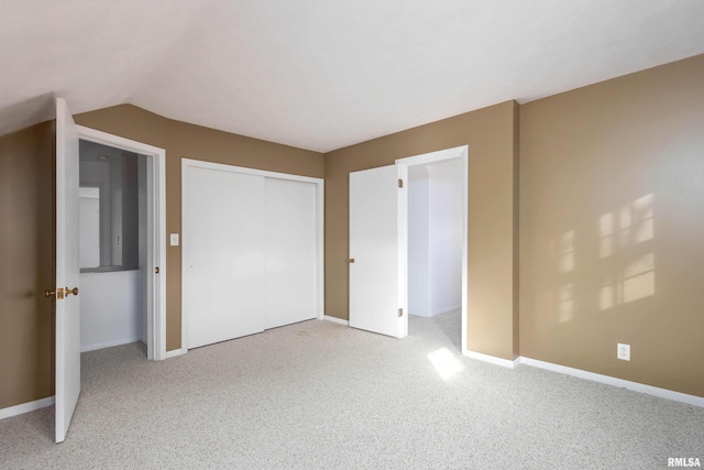 unfurnished bedroom with light carpet, vaulted ceiling, and a closet