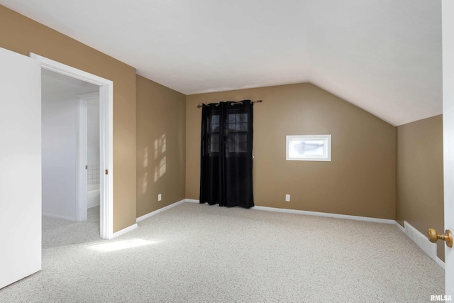 bonus room featuring vaulted ceiling and light colored carpet