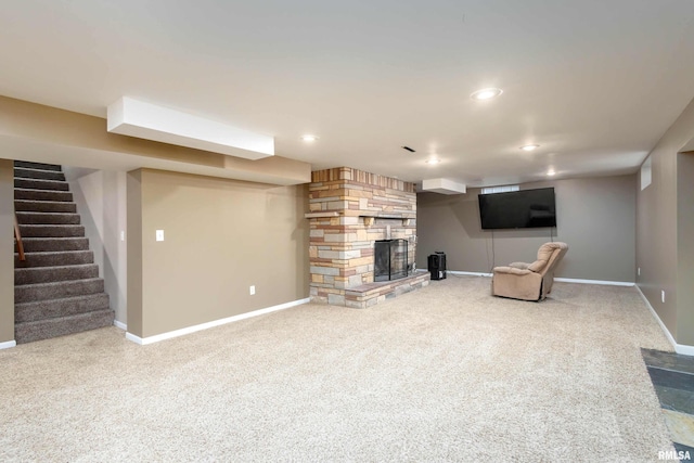 basement with a stone fireplace and carpet flooring