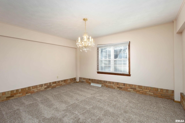 carpeted spare room featuring crown molding and a notable chandelier