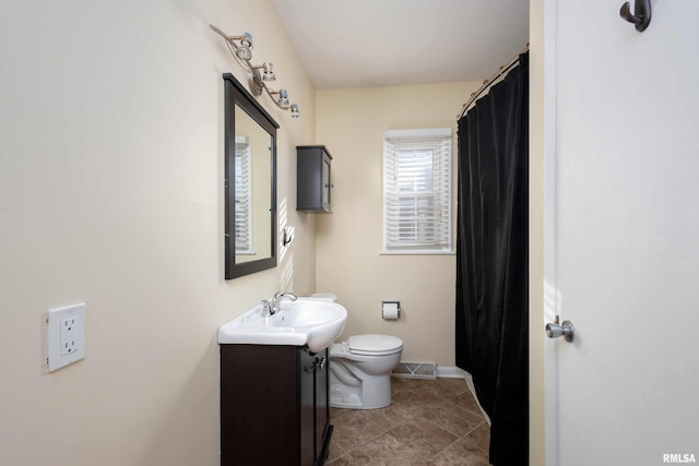 bathroom featuring tile patterned flooring, vanity, and toilet