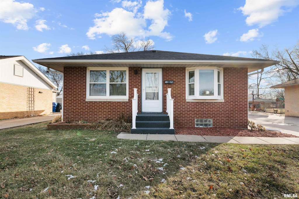 bungalow-style house featuring a front lawn