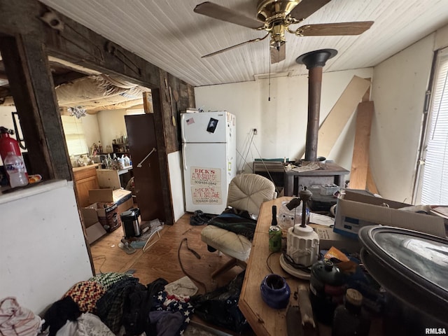 miscellaneous room with ceiling fan and a wood stove