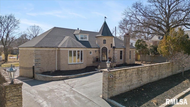 rear view of property featuring a gate, a shingled roof, and fence