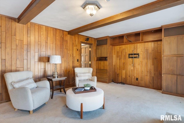 living area with beam ceiling, carpet floors, and wood walls