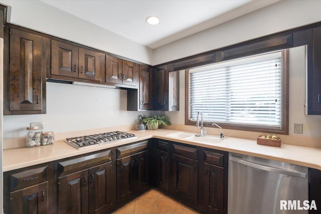 kitchen with recessed lighting, a sink, stainless steel appliances, light countertops, and dark brown cabinets