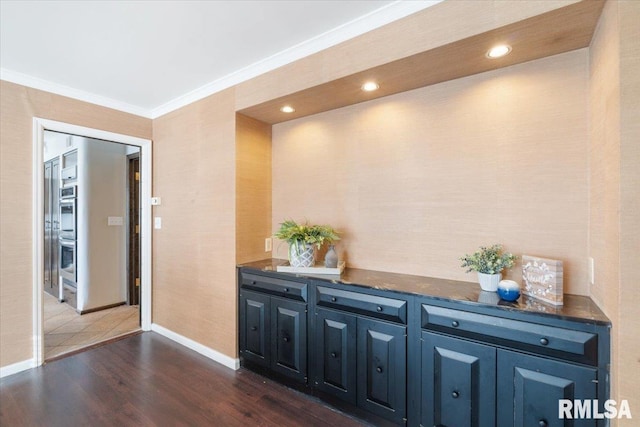 hallway with recessed lighting, dark wood-type flooring, baseboards, and ornamental molding