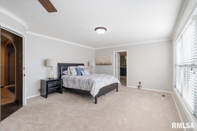 carpeted bedroom featuring crown molding, arched walkways, and baseboards