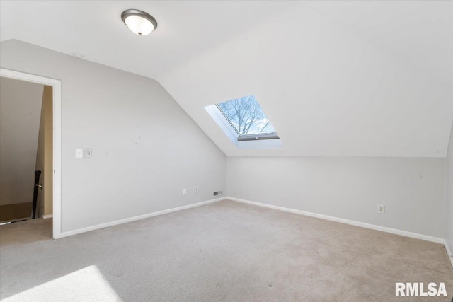 bonus room featuring carpet flooring, vaulted ceiling with skylight, and visible vents