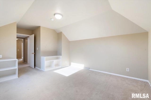 additional living space with baseboards, lofted ceiling, and carpet floors