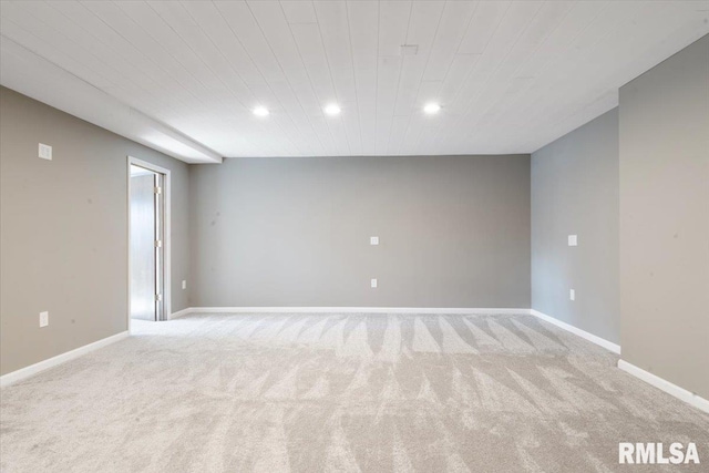 empty room featuring recessed lighting, baseboards, and light carpet