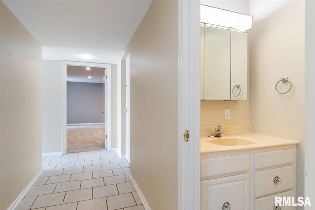 bathroom with vanity, baseboards, and tile patterned flooring