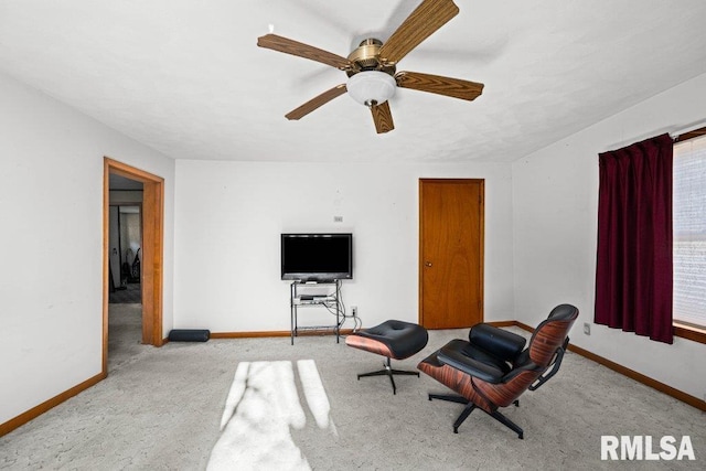 living area with light carpet and ceiling fan