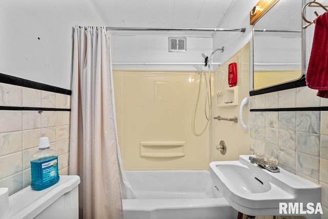 full bathroom featuring toilet, tile walls, sink, and shower / bath combination with curtain