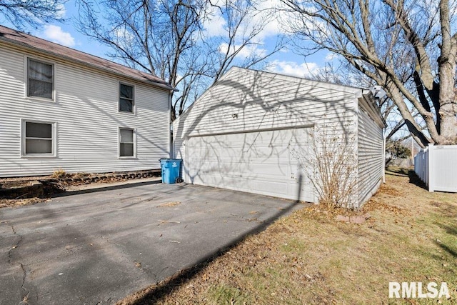 view of side of property featuring a garage and an outbuilding