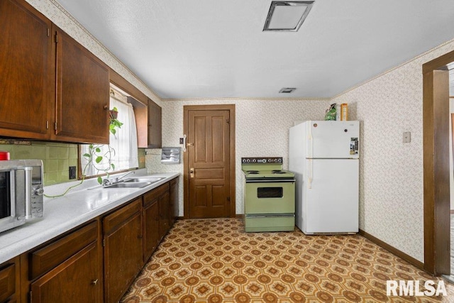 kitchen with tasteful backsplash, electric range oven, white fridge, sink, and ornamental molding