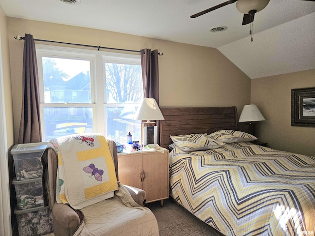 carpeted bedroom with ceiling fan and vaulted ceiling