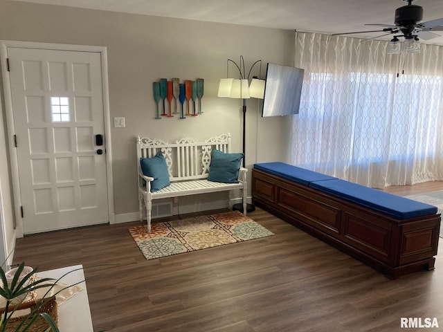 living area featuring dark wood-type flooring, a healthy amount of sunlight, and ceiling fan