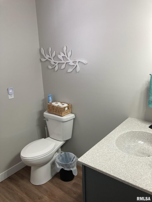 bathroom with hardwood / wood-style floors, toilet, and vanity