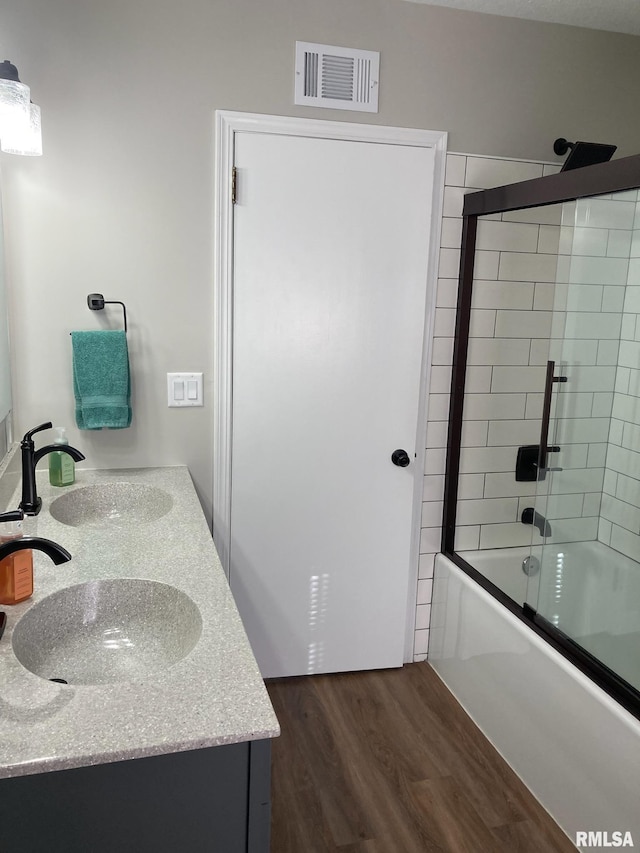 bathroom featuring wood-type flooring, vanity, and shower / bath combination with glass door