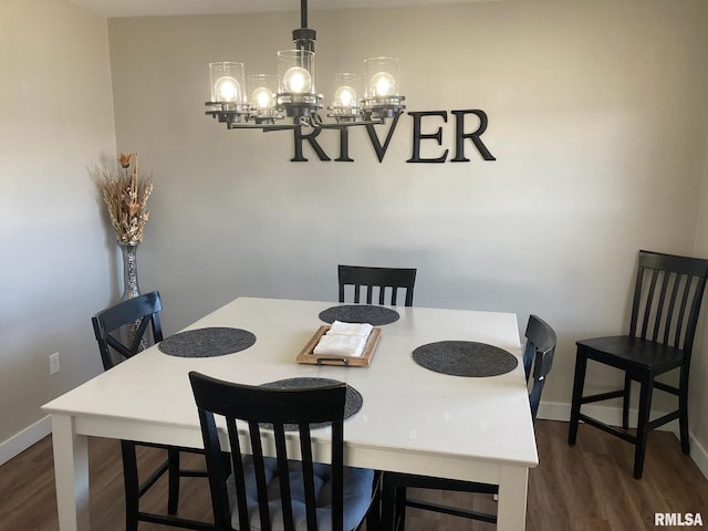 dining area featuring dark wood-type flooring and a notable chandelier