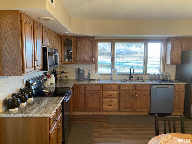 kitchen featuring sink, backsplash, appliances with stainless steel finishes, and dark hardwood / wood-style floors