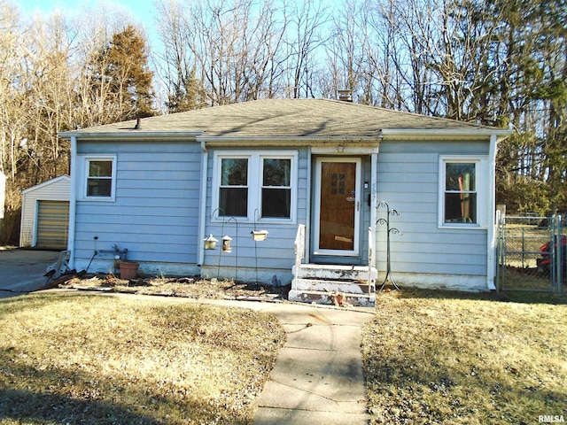 bungalow-style house with a garage and an outbuilding