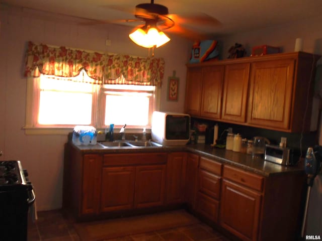 kitchen featuring black stove, sink, and ceiling fan