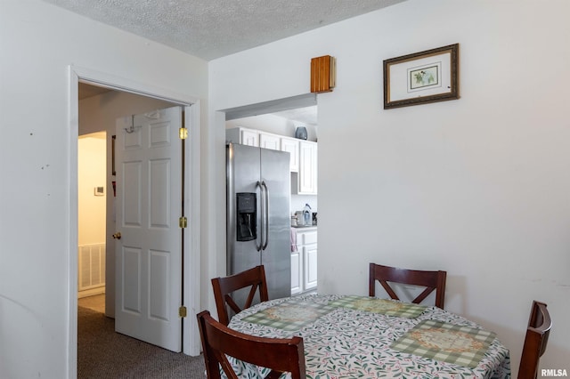 dining room featuring a textured ceiling and carpet flooring