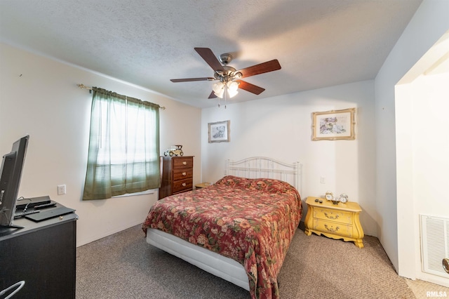 carpeted bedroom with ceiling fan and a textured ceiling