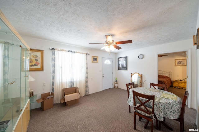 carpeted dining space with ceiling fan and a textured ceiling