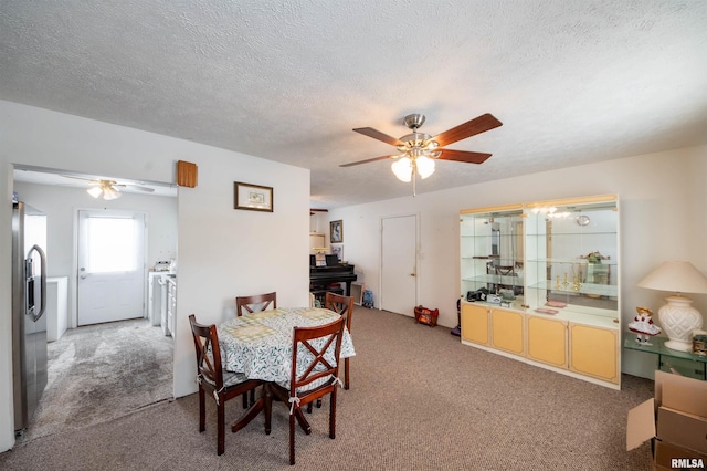 carpeted dining space with ceiling fan and a textured ceiling