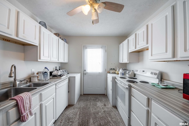 kitchen with white appliances, a textured ceiling, white cabinetry, light carpet, and sink