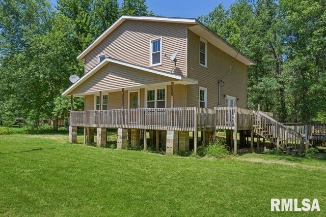 rear view of property with a wooden deck and a yard