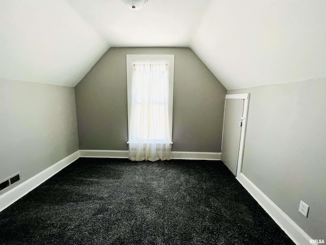 additional living space featuring vaulted ceiling and dark carpet