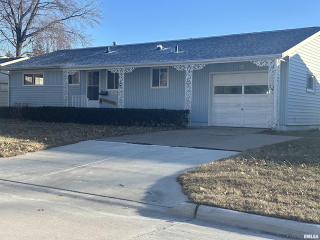 single story home with covered porch, an attached garage, and driveway