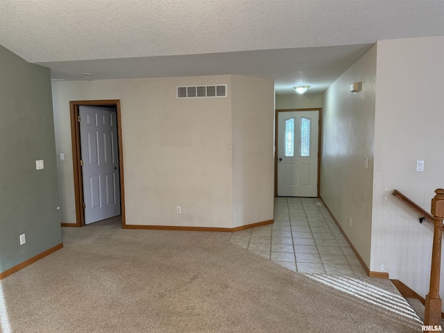 carpeted spare room with a textured ceiling